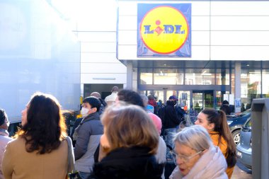 Brüksel, Belçika. 18 Mart 2020. Müşteriler, Belçika hükümeti Coronavirus 'u kapatmadan önce süpermarketin önünde kuyrukta bekliyorlar..