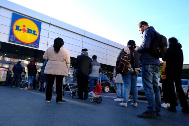 Brüksel, Belçika. 18 Mart 2020. Müşteriler, Belçika hükümeti Coronavirus 'u kapatmadan önce süpermarketin önünde kuyrukta bekliyorlar..