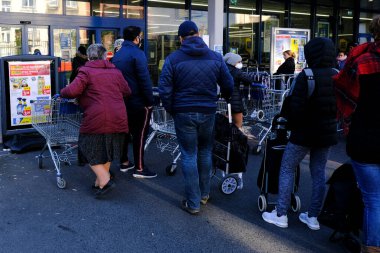 Brüksel, Belçika. 18 Mart 2020. Müşteriler, Belçika hükümeti Coronavirus 'u kapatmadan önce süpermarketin önünde kuyrukta bekliyorlar..