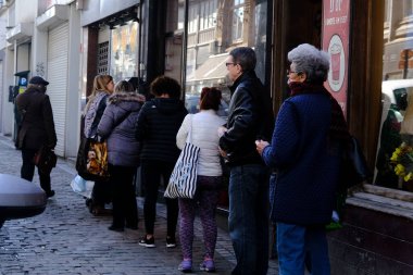 Brüksel, Belçika. 18 Mart 2020. Müşteriler, Belçika hükümeti Coronavirus 'u kapatmadan önce süpermarketin önünde kuyrukta bekliyorlar..