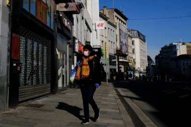 Brüksel, Belçika. 18 Mart 2020. Koronavirüs salgını sonrasında koruyucu yüz maskeleri takan insanlar Brüksel 'in tarihi merkezine doğru yol alıyorlar..
