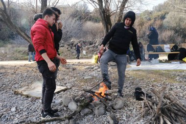 Göçmenler 4 Mart 2020 'de Yunanistan' ın Skala Sikamineas köyü yakınlarında bir şenlik ateşinin yanında ısındılar..