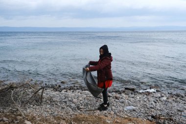 Mülteciler ve göçmenler 4 Mart 2020 'de Yunanistan' ın Lezbiyen Adası 'ndaki Skala Sikamias köyünden Mytilene limanına nakledilmeyi bekliyorlar..