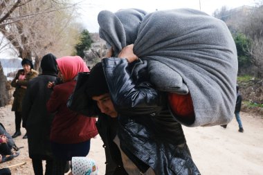 Mülteciler ve göçmenler 4 Mart 2020 'de Yunanistan' ın Lezbiyen Adası 'ndaki Skala Sikamias köyünden Mytilene limanına nakledilmeyi bekliyorlar..
