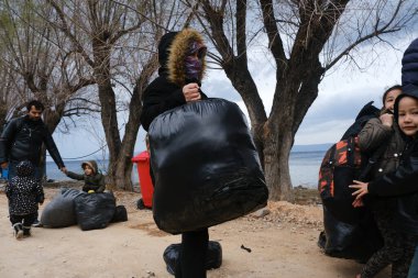 Mülteciler ve göçmenler 4 Mart 2020 'de Yunanistan' ın Lezbiyen Adası 'ndaki Skala Sikamias köyünden Mytilene limanına nakledilmeyi bekliyorlar..