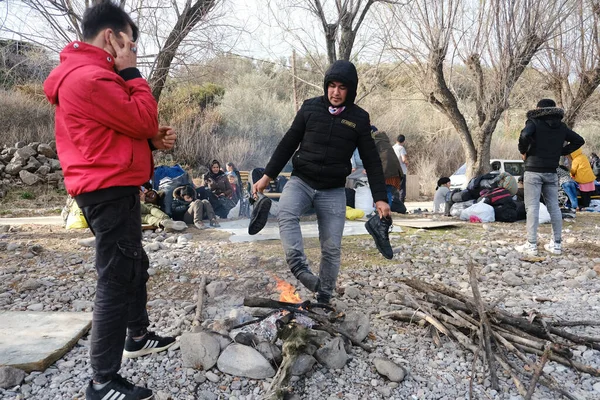 Göçmenler 4 Mart 2020 'de Yunanistan' ın Skala Sikamineas köyü yakınlarında bir şenlik ateşinin yanında ısındılar..