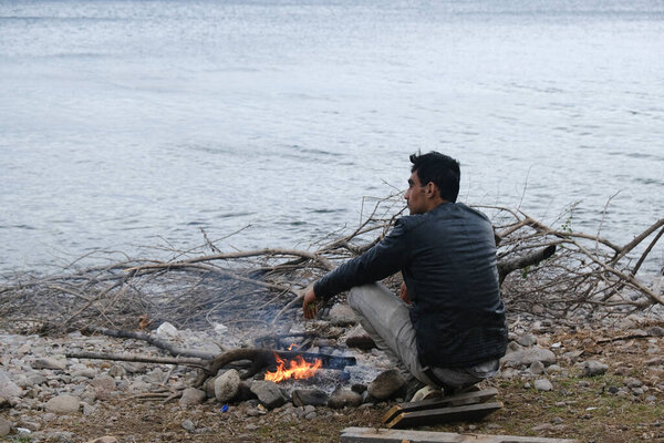 Migrants warm themselves next to a bonfire near the village of Skala Sikamineas, Greece, March 4, 2020.