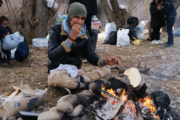 Migrants warm themselves next to a bonfire near the village of Skala Sikamineas, Greece, March 4, 2020.