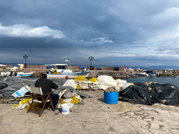 LESBOS ISLAND, GREECE - March 4, 2020. A Fisherman prpeares nets in port. Greek islands are famous for traditional boats used to catch fish — Stock Image Lesbos Island Greece March 2020 Fisherman Prpeares Nets Port Greek Royalty Free Stock Images