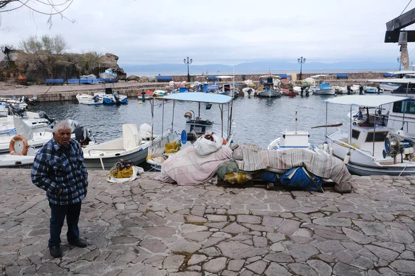 LESBOS ISLAND, GREECE - March 5, 2020. A Fisherman prpeares nets in port. Greek islands are famous for traditional boats used to catch fish — Stock Image Lesbos Island Greece March 2020 Fisherman Prpeares Nets Port Greek Stock Picture
