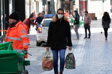 Belçika 24 Mart 2020 'de Brüksel, Belçika' da Coronavirus hastalığının yayılmasını yavaşlatmak için şehir merkezinde yürüyen koruyucu yüz maskesi takan bir yaya görülüyor.