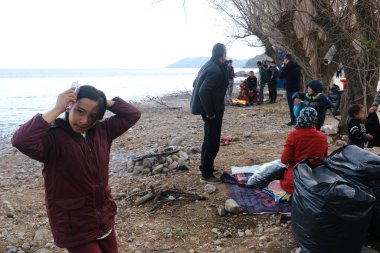 Mülteciler ve göçmenler 4 Mart 2020 'de Yunanistan' ın Lezbiyen Adası 'ndaki Skala Sikamias köyünden Mytilene limanına nakledilmeyi bekliyorlar..