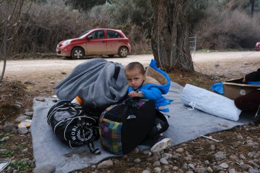 Refugees and Migrants wait to be transferred to the port of Mytilene from the village of Skala Sikamias, on the island of Lesbos, Greece, March 4, 2020. clipart