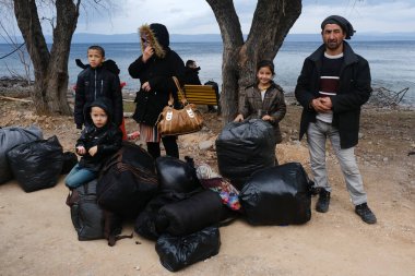 Mülteciler ve göçmenler 4 Mart 2020 'de Yunanistan' ın Lezbiyen Adası 'ndaki Skala Sikamias köyünden Mytilene limanına nakledilmeyi bekliyorlar..