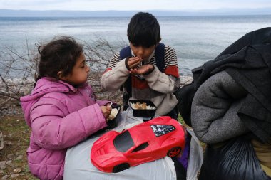 Mülteciler ve göçmenler 4 Mart 2020 'de Yunanistan' ın Lezbiyen Adası 'ndaki Skala Sikamias köyünden Mytilene limanına nakledilmeyi bekliyorlar..