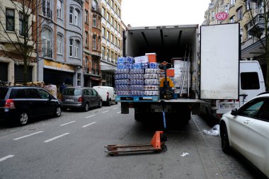 Belçika 'nın başkenti Brüksel' de 19 Mart 2020 'de meydana gelen koronavirüs hastalığının yayılmasını yavaşlatmak için işçiler hipermarkette mal tedarik ediyorlar.
