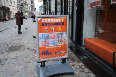 İnsanlar 19 Mart 2020 'de Brüksel, Belçika' daki Ria Para Aktarım ofisinin önünde yürüyorlar