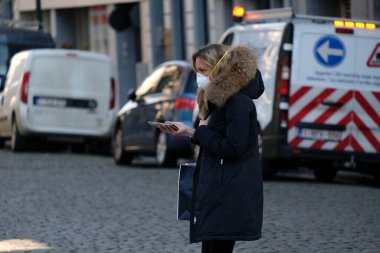 Belçika 26 Mart 2020 'de Brüksel, Belçika' da Coronavirus hastalığının yayılmasını yavaşlatmak için şehir merkezinde yürüyen koruyucu yüz maskesi takan bir yaya görülüyor.
