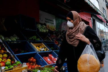 Yüz maskesi takan bir alışverişçi sabahın erken saatlerinde Brüksel 'in Molenbeek bölgesindeki bir markete alışverişe gider. 19, 2020.