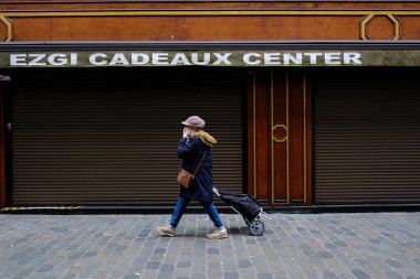 Belçika 19 Mart 2020 'de Brüksel, Belçika' da koronavirüs hastalığının yayılmasını yavaşlatmak için şehir merkezinde yürüyen koruyucu yüz maskesi takan bir yaya görülüyor.