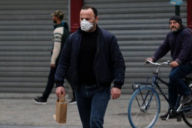 Belçika 19 Mart 2020 'de Brüksel, Belçika' da koronavirüs hastalığının yayılmasını yavaşlatmak için şehir merkezinde yürüyen koruyucu yüz maskesi takan bir yaya görülüyor.