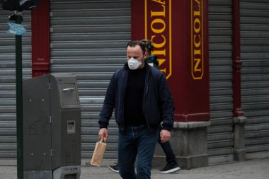Belçika 19 Mart 2020 'de Brüksel, Belçika' da koronavirüs hastalığının yayılmasını yavaşlatmak için şehir merkezinde yürüyen koruyucu yüz maskesi takan bir yaya görülüyor.