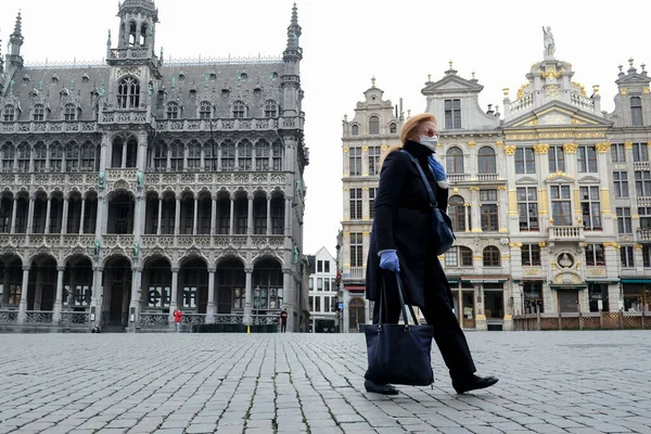 在比利时布鲁塞尔 一名戴着防护面罩的行人于2020年3月19日实施封锁 以减缓眼镜蛇疾病的蔓延 随后这名行人走进了市中心 — 图库照片