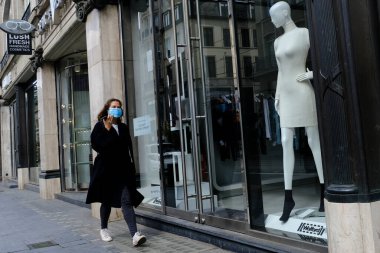 Belçika 'nın 30 Nisan 2020' de Brüksel, Belçika 'da Coronavirus hastalığının yayılmasını yavaşlatmak için şehir merkezinde yürüyen koruyucu maskeli bir yaya görülüyor..