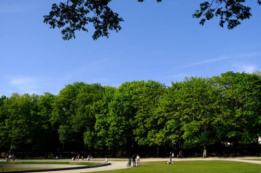 24 Nisan 2020 'de Brüksel' de güneşli bir günde insanlar parkta dolaşırken, COVID-19 'un yayılmasını önlemek için son beş haftadır sıkı bir tecrit uygulanıyor..