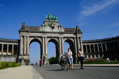 24 Nisan 2020 'de Brüksel, Belçika' da güneşli bir günde, yüz maskesi takan bir yaya Parc du Cinquantenaire 'de yürür..