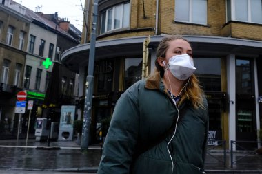 Belçika 'nın 28 Nisan 2020' de Brüksel, Belçika 'da koronavirüs hastalığının yayılmasını yavaşlatmak için şehir merkezinde yürüyen koruyucu maskeli bir yaya görülüyor..