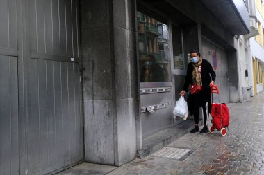 Belçika 'nın 28 Nisan 2020' de Brüksel, Belçika 'da koronavirüs hastalığının yayılmasını yavaşlatmak için şehir merkezinde yürüyen koruyucu maskeli bir yaya görülüyor..