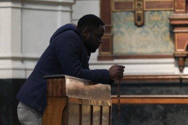 10 Nisan 2020 Cuma günü Belçika 'nın başkenti Brüksel' de Covid-19 'un yayılmasını önlemek için yapılan bir ayinden sonra insanlar Saint Catherine kilisesinde dua ediyorlar..