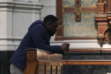 10 Nisan 2020 Cuma günü Belçika 'nın başkenti Brüksel' de Covid-19 'un yayılmasını önlemek için yapılan bir ayinden sonra insanlar Saint Catherine kilisesinde dua ediyorlar..