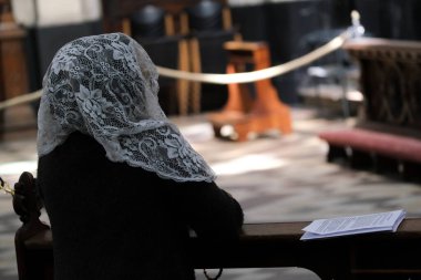 10 Nisan 2020 Cuma günü Belçika 'nın başkenti Brüksel' de Covid-19 'un yayılmasını önlemek için yapılan bir ayinden sonra insanlar Saint Catherine kilisesinde dua ediyorlar..