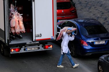 Bir kasap dükkanı çalışanı 8 Nisan 2020 'de Brüksel, Belçika' da bir nakliye kamyonundan et indirirken küresel COVID-19 koronavirüs salgınına karşı önlem olarak yüz maskesi takıyor.