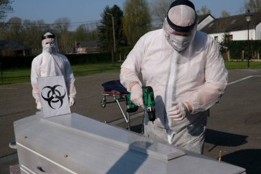 Bir morg çalışanı Belçika 'nın Gilly kentinde bulunan Coronavirus Hastalığı (COVID-19) kurbanının tabutunu kapatır. 9, 2020.