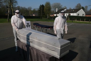 Pompes Funebres Fontaine 'in cenaze levazımatçıları koruyucu giysiler içinde Belçika, Gilly' deki bir COVID 19 kurbanının tabutunu taşıyorlar. 9, 2020