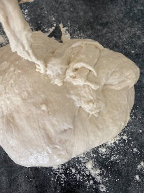 Bir kadın pizza yapmak için hamur hazırlar.