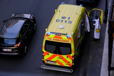 4 Haziran 2020 'de Brüksel, Belçika' da COVID-19 ile enfekte olduğundan şüphelenilen, kişisel koruma ekipmanı (PPE) taşıyan bir itfaiyeci bir hastayı sedyeye bindirmeye geliyor..