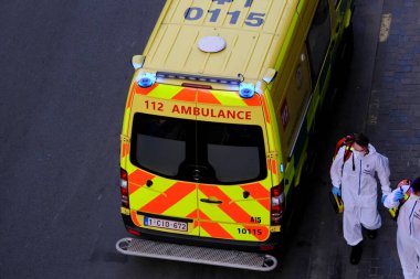 4 Haziran 2020 'de Brüksel, Belçika' da COVID-19 ile enfekte olduğundan şüphelenilen, kişisel koruma ekipmanı (PPE) taşıyan bir itfaiyeci bir hastayı sedyeye bindirmeye geliyor..