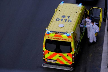 4 Haziran 2020 'de Brüksel, Belçika' da COVID-19 ile enfekte olduğundan şüphelenilen, kişisel koruma ekipmanı (PPE) taşıyan bir itfaiyeci bir hastayı sedyeye bindirmeye geliyor..