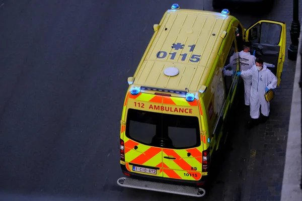 4 Haziran 2020 'de Brüksel, Belçika' da COVID-19 ile enfekte olduğundan şüphelenilen, kişisel koruma ekipmanı (PPE) taşıyan bir itfaiyeci bir hastayı sedyeye bindirmeye geliyor..
