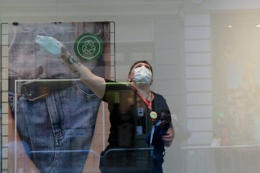 Bir giyim mağazasının çalışanı, 4 Haziran 2020 'de Brüksel, Belçika' da açılmadan önce bir alışveriş penceresini temizler..