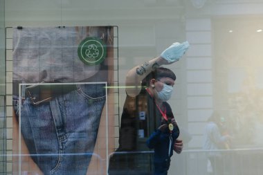Bir giyim mağazasının çalışanı, 4 Haziran 2020 'de Brüksel, Belçika' da açılmadan önce bir alışveriş penceresini temizler..