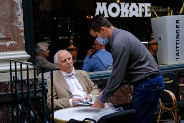 Koruyucu maske takan bir garson, Belçika 'nın Brüksel kentinde meydana gelen koronavirüs hastalığının ortasında haftalar süren tecrit kısıtlamaları sonrasında restoranlar ve barlar olarak müşteriye hizmet veriyor. 8, 2020.