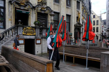 8 Haziran 2020 'de Belçika' da meydana gelen koronavirüs hastalığı (COVID-19) salgını sonrasında ülke tecrit kısıtlamalarını gevşetmeye başladığında, Brüksel 'in merkezinde bir restoranın teraslarını hazırlayan bir çalışan görülüyor.