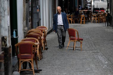 8 Haziran 2020 'de Belçika' da meydana gelen koronavirüs hastalığı (COVID-19) salgını sonrasında ülke tecrit kısıtlamalarını gevşetmeye başladığında, Brüksel 'in merkezinde bir restoranın teraslarını hazırlayan bir çalışan görülüyor.