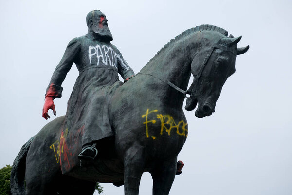 A statue of Belgium's King Leopold II is smeared with red paint and graffiti in Brussels, Belgium on June 10, 2020. 