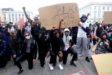 George Floyd 'un Brüksel, Belçika' da öldürülmesinin ardından ırkçılık karşıtı bir protesto sırasında protestocular yumruklarını kaldırdılar. 7, 2020.